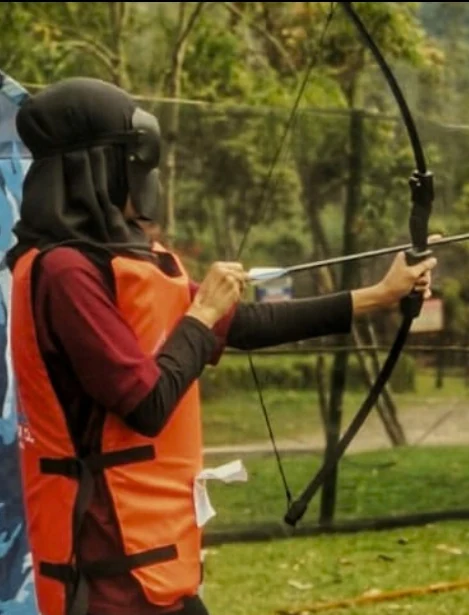Archery War/Target — Foto kegiatan dari booklet JO Adventure Peserta memegang busur panah saat permainan archery di area terbuka